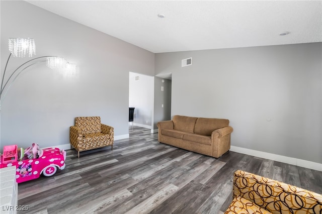 living room with visible vents, baseboards, vaulted ceiling, and wood finished floors