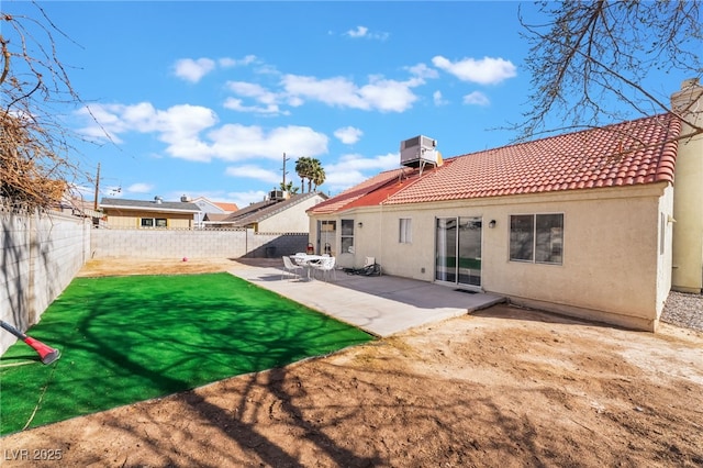 rear view of house featuring a patio, central AC unit, a fenced backyard, a tile roof, and stucco siding