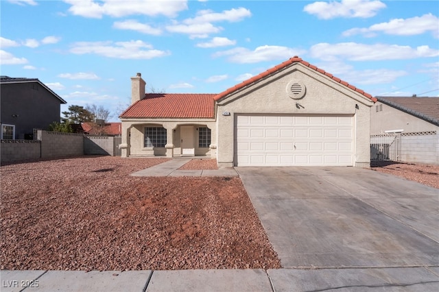 mediterranean / spanish house with fence, a tiled roof, driveway, stucco siding, and a chimney