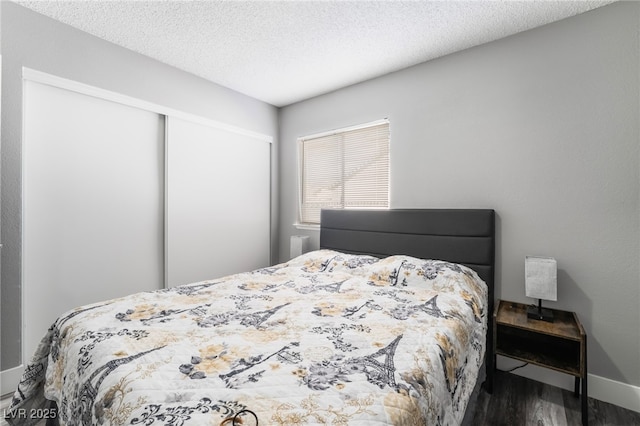 bedroom with a textured ceiling, a closet, and wood finished floors