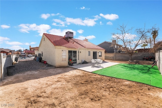 back of property featuring a tiled roof, a patio area, a fenced backyard, and stucco siding