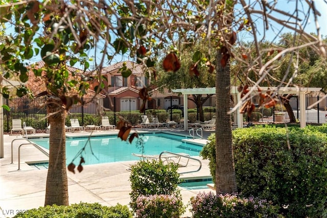 community pool with a patio and fence