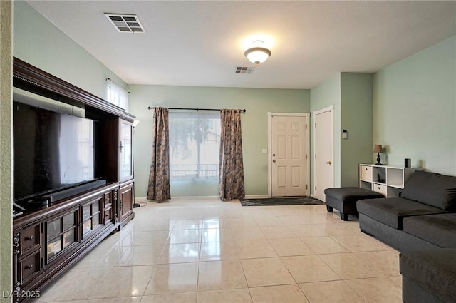 living area featuring light tile patterned flooring, visible vents, and baseboards