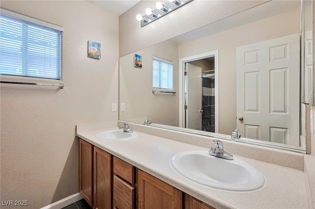 bathroom with double vanity, walk in shower, and a sink