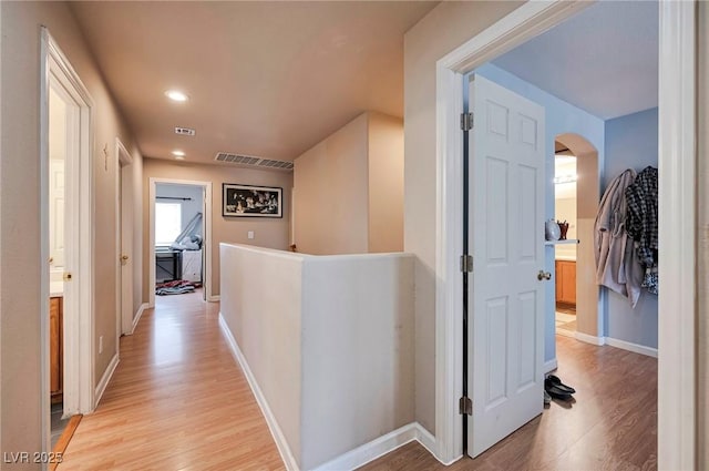 hallway featuring recessed lighting, visible vents, an upstairs landing, baseboards, and light wood-type flooring