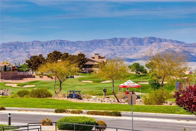 surrounding community with a yard, golf course view, and a mountain view