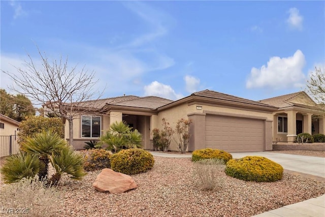 view of front of house featuring stucco siding, fence, concrete driveway, an attached garage, and a tiled roof