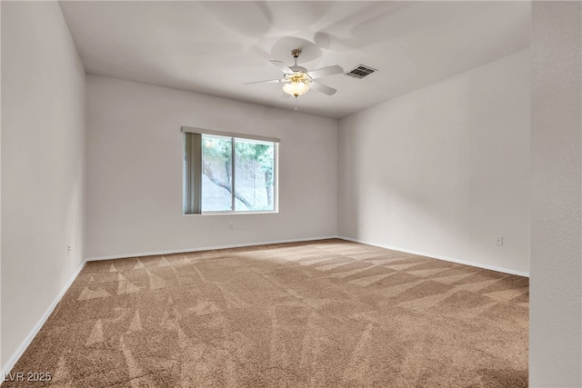 unfurnished room with visible vents, light carpet, baseboards, and a ceiling fan