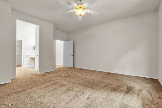 unfurnished bedroom featuring a walk in closet, baseboards, ceiling fan, and carpet flooring