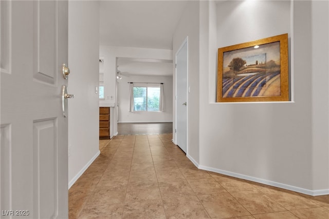 hall featuring baseboards and tile patterned flooring