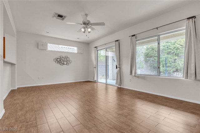 spare room with visible vents, baseboards, ceiling fan, and wood finished floors