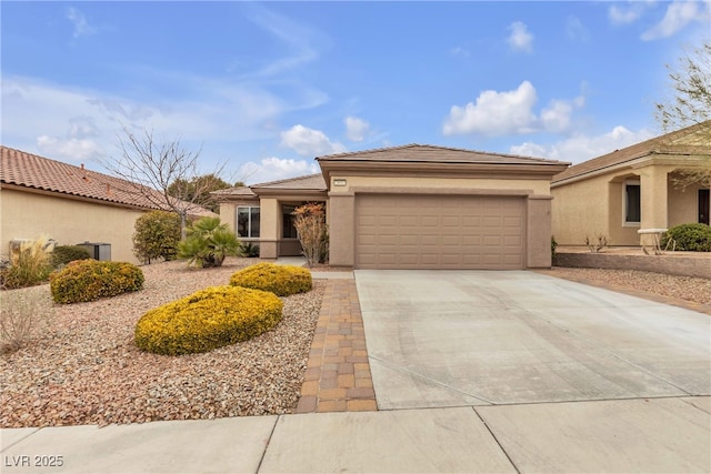 view of front of home with stucco siding, a tiled roof, concrete driveway, and a garage