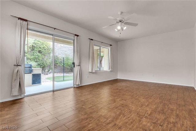 unfurnished room with ceiling fan, baseboards, and wood finished floors