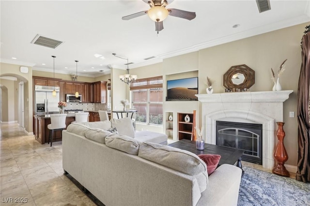 living room featuring visible vents, arched walkways, and ornamental molding