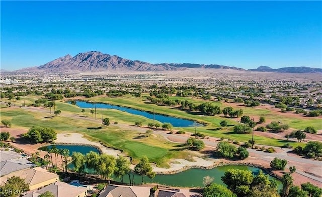 drone / aerial view with view of golf course and a water and mountain view