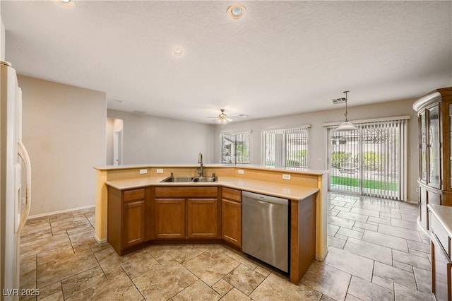 kitchen with a sink, light countertops, dishwasher, and freestanding refrigerator