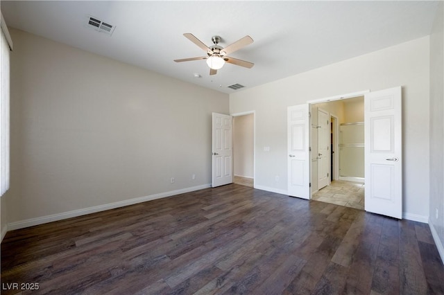 unfurnished bedroom with dark wood-type flooring, visible vents, and baseboards