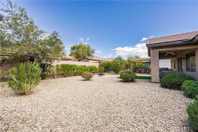 view of yard with a patio, fence, and a ceiling fan