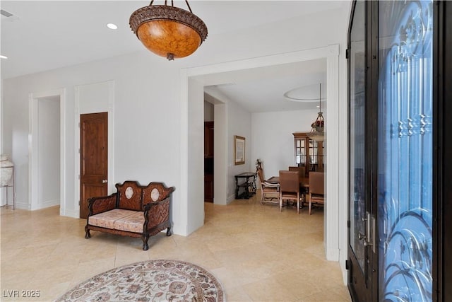 foyer entrance with baseboards and recessed lighting