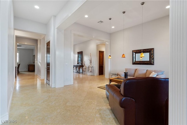 living area featuring baseboards, visible vents, and recessed lighting