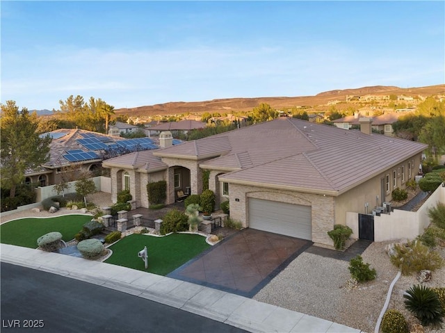 view of front of home featuring an attached garage, fence, concrete driveway, and a tiled roof