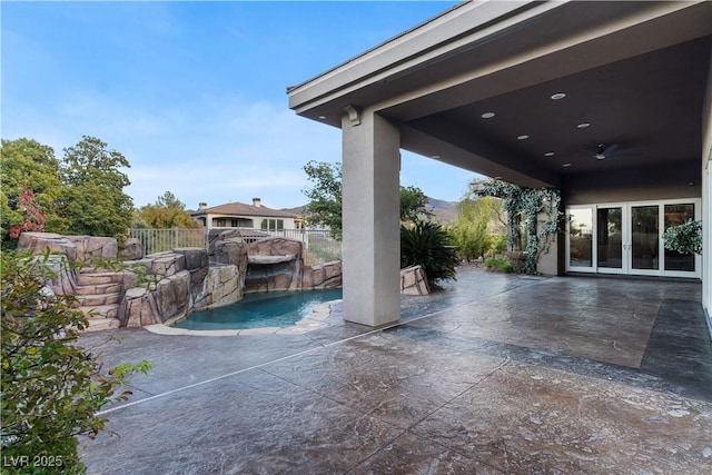 view of patio / terrace with fence, a fenced in pool, and french doors