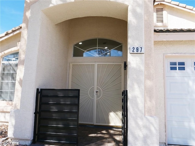 entrance to property featuring a tile roof and stucco siding