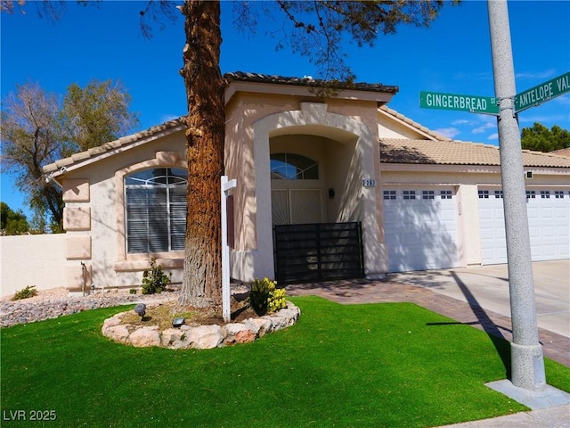 mediterranean / spanish-style house featuring driveway, a front lawn, a tile roof, and stucco siding