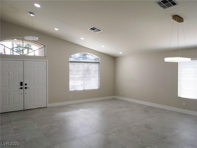 foyer featuring vaulted ceiling, visible vents, and plenty of natural light