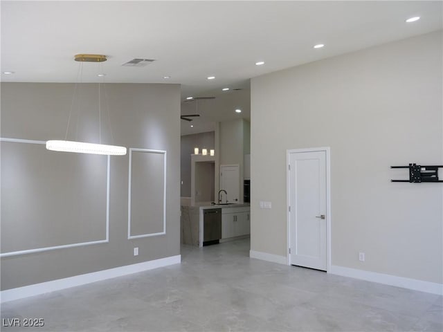 spare room featuring recessed lighting, visible vents, a high ceiling, a sink, and baseboards