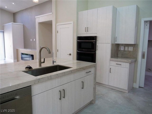 kitchen with dobule oven black, decorative backsplash, stainless steel dishwasher, a sink, and light stone countertops