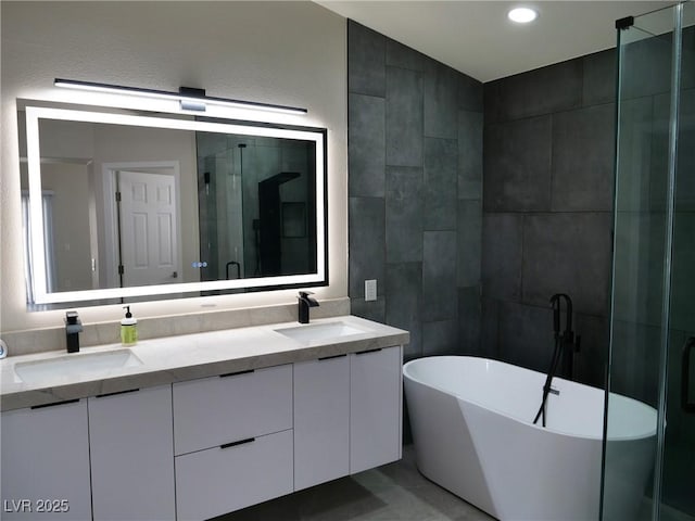 full bath with double vanity, a shower stall, tile walls, and a sink