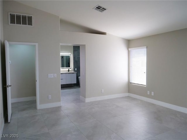 unfurnished bedroom featuring visible vents, vaulted ceiling, and baseboards