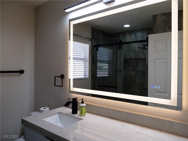 bathroom featuring a shower stall and vanity