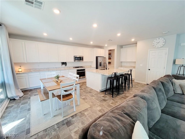 kitchen with open floor plan, stainless steel appliances, visible vents, and recessed lighting