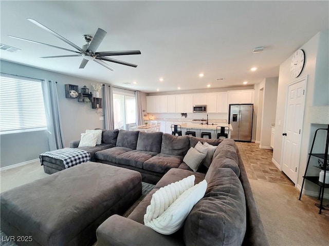 living area with light carpet, baseboards, visible vents, and recessed lighting