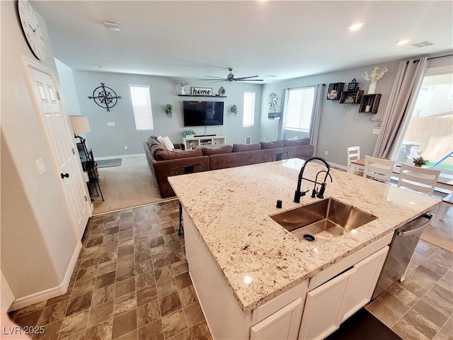 kitchen featuring a healthy amount of sunlight, dishwasher, a kitchen island with sink, and a sink