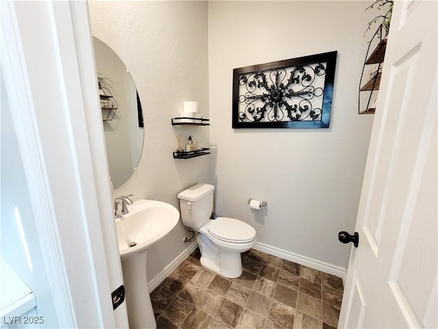 bathroom featuring a sink, toilet, and baseboards