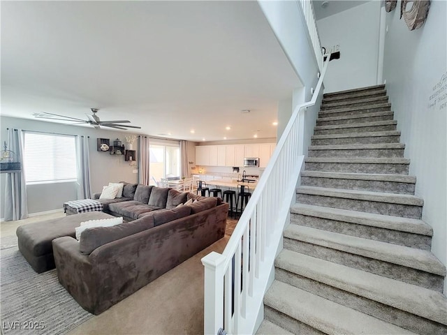 living room with ceiling fan, stairway, a wealth of natural light, and recessed lighting