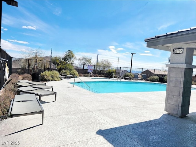 community pool featuring fence and a patio