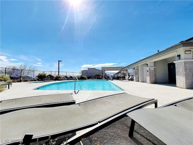 community pool with fence and a patio