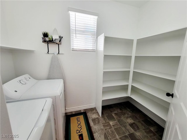 washroom featuring laundry area, washing machine and clothes dryer, and baseboards