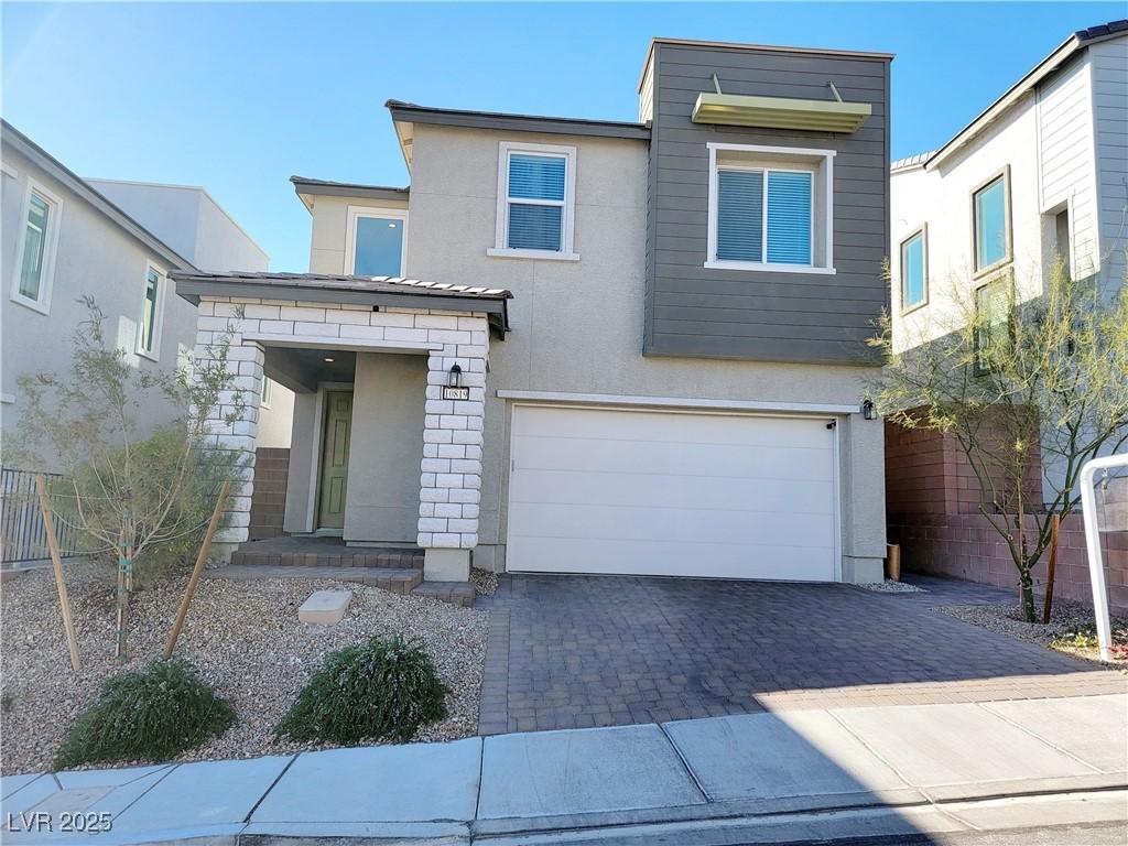 10819 Far Country Ave, Las Vegas, NV 89129 - modern home featuring a garage, stucco siding, and decorative driveway