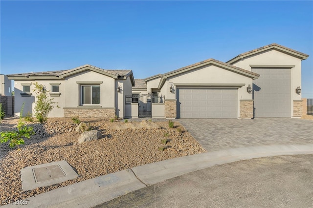 view of front facade with an attached garage, fence, decorative driveway, a gate, and stucco siding