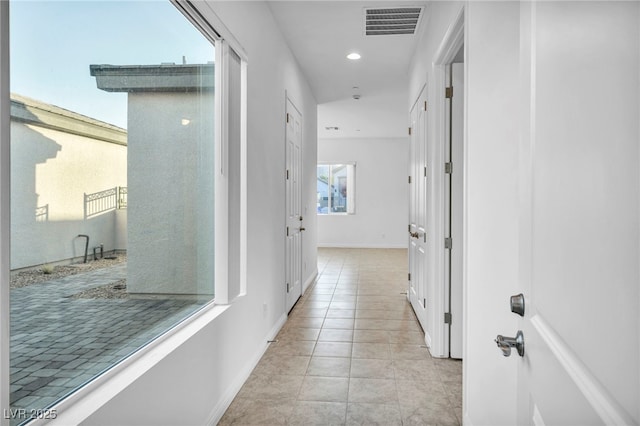 hall featuring light tile patterned floors, baseboards, visible vents, and recessed lighting