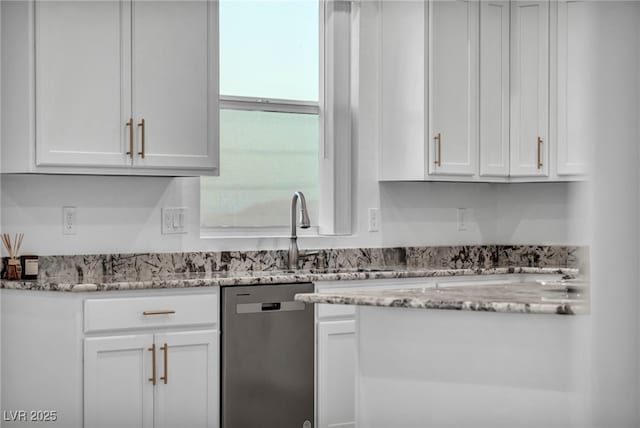 kitchen with light stone counters, white cabinets, dishwasher, and a sink