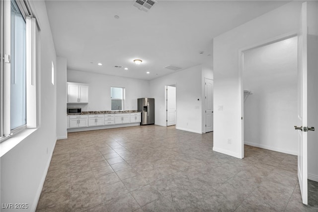 unfurnished living room with baseboards, visible vents, and recessed lighting