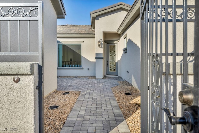 view of exterior entry featuring a tile roof and stucco siding