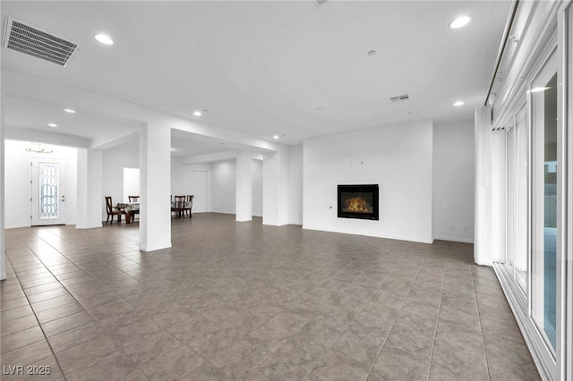 unfurnished living room featuring recessed lighting, visible vents, and a glass covered fireplace