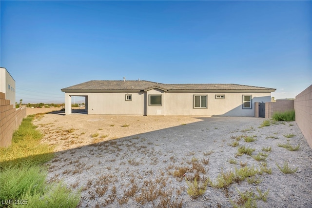 back of property with fence and stucco siding